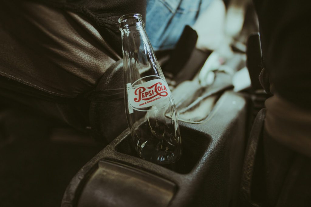 coke bottle with vintage branding sits in car console